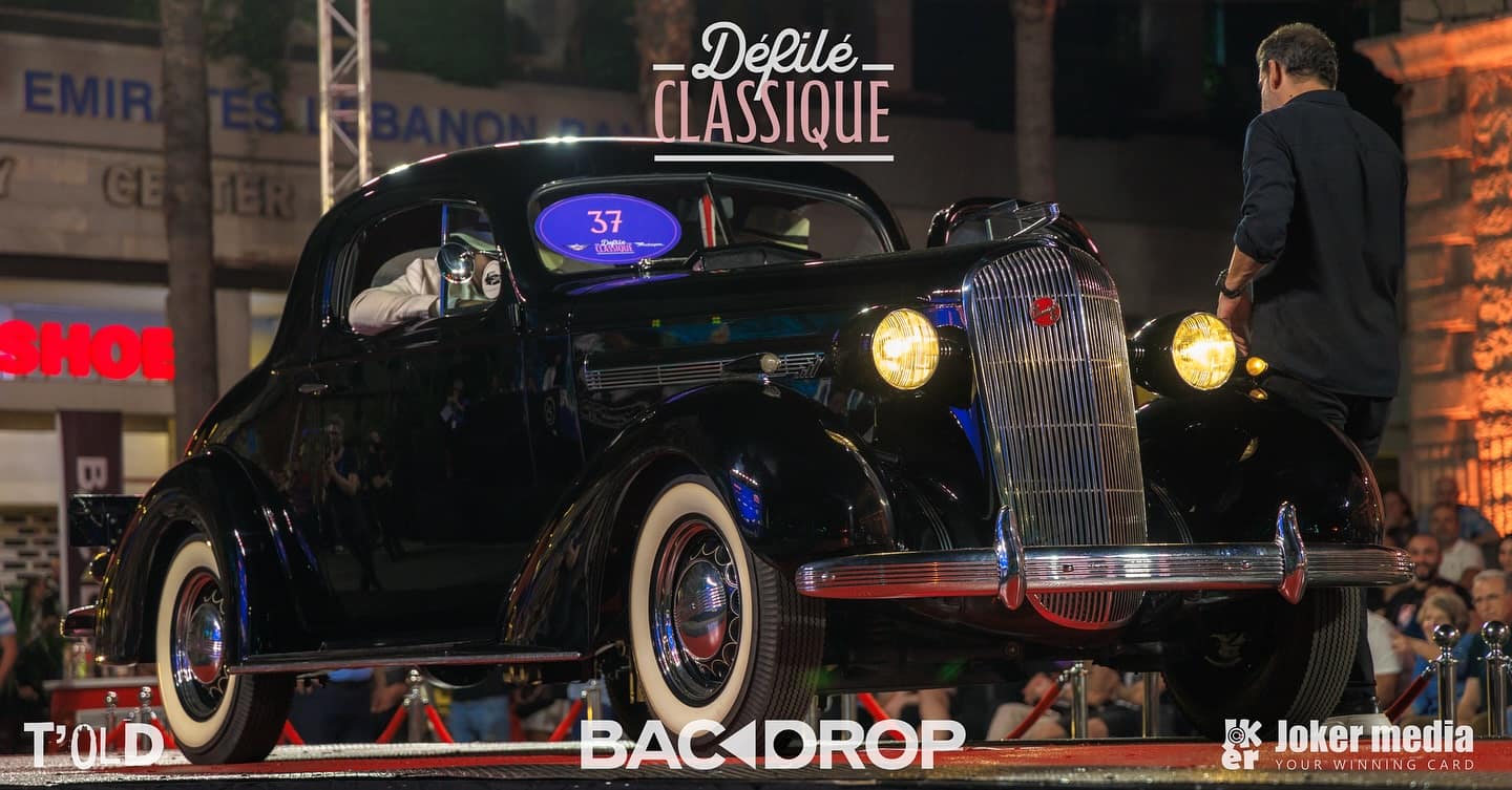 The 1936 Buick Business on the red stage at night, crowned Best Classic Car of 2025